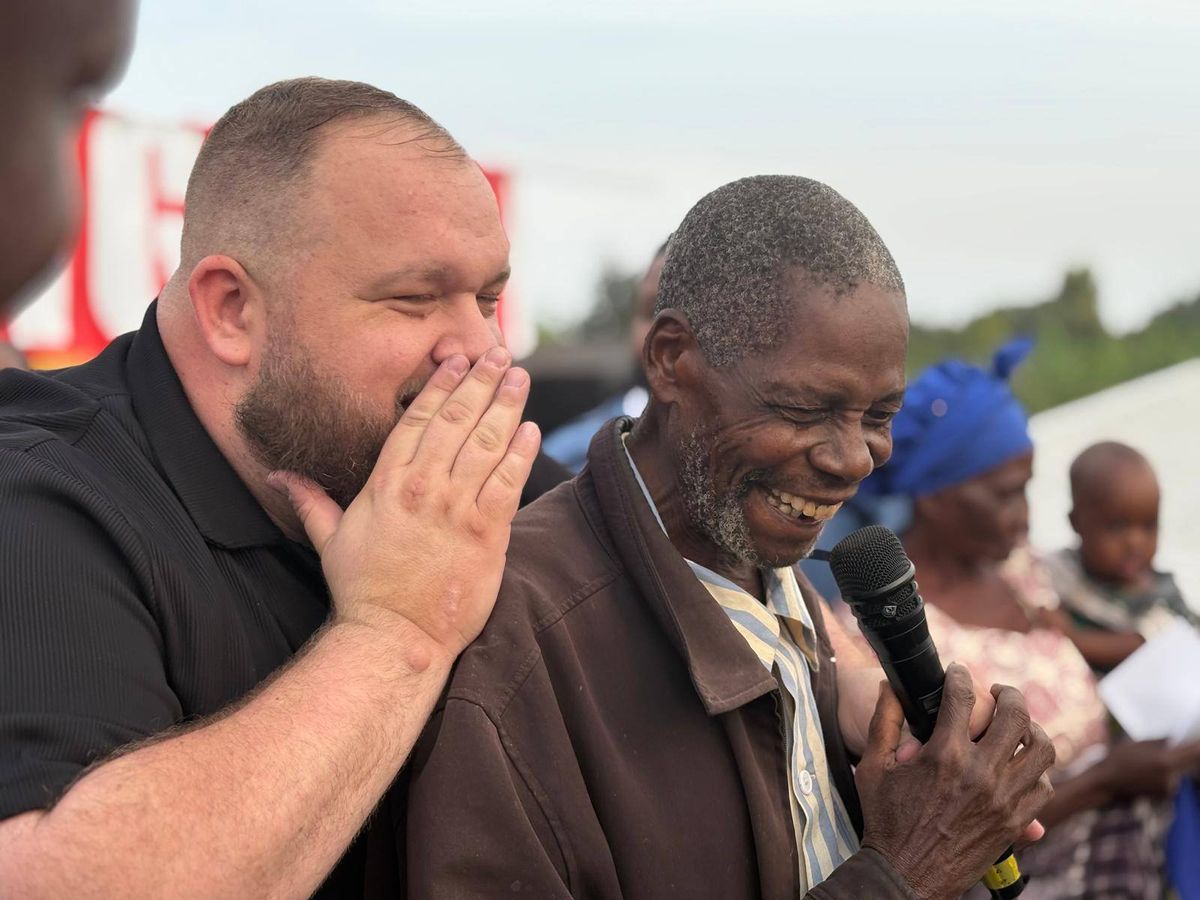A man healed at the Chato festival, laughing with Dean Morris